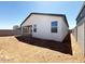 View of the backyard, showing an expansive area ready for landscaping and customization, with a covered patio attached to the house at 47734 W Moeller Rd, Maricopa, AZ 85139