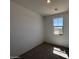 Bright bedroom with plush gray carpeting, natural light from the window, and neutral walls creating a relaxing atmosphere at 47734 W Moeller Rd, Maricopa, AZ 85139