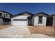 A single-story home with a white stucco finish, complemented by a 2-car garage and desert landscaping in the front yard at 47734 W Moeller Rd, Maricopa, AZ 85139