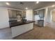 Modern kitchen with gray cabinets, sleek black countertops, tile backsplash, and an island with a sink and breakfast bar at 47734 W Moeller Rd, Maricopa, AZ 85139