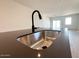 Close-up of a modern kitchen sink with a black faucet and stainless steel basin on a dark countertop at 47734 W Moeller Rd, Maricopa, AZ 85139