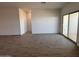 Spacious living room with wood-look tile flooring, neutral walls, and large sliding doors, offering seamless indoor-outdoor living at 47734 W Moeller Rd, Maricopa, AZ 85139