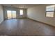 Bright living room with wood-look tile flooring, sliding glass doors, and large windows providing plenty of natural light at 47734 W Moeller Rd, Maricopa, AZ 85139