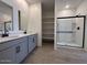Main bathroom features dual sinks, gray cabinetry, and a glass-enclosed shower at 47734 W Moeller Rd, Maricopa, AZ 85139