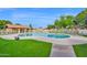 Community pool surrounded by lush green grass and chaise lounges, perfect for relaxation at 5505 E Mclellan Rd # 41, Mesa, AZ 85205