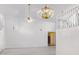 Bright living room with decorative wall panels, chandelier, fan, and white walls and staircase at 5742 W Shannon St, Chandler, AZ 85226