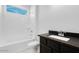 Bright bathroom with a shower-tub combo and modern black countertop sink at 5779 N 207Th Ave, Buckeye, AZ 85396