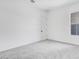 Bedroom featuring a window, plush carpeting and neutral paint with an adjacent door at 5779 N 207Th Ave, Buckeye, AZ 85396