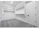 Walk-in closet featuring carpeted floors and white shelving for organized storage at 5779 N 207Th Ave, Buckeye, AZ 85396
