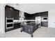 Spacious kitchen featuring dark cabinets, stainless steel appliances, and a functional kitchen island at 5779 N 207Th Ave, Buckeye, AZ 85396