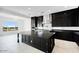 Modern kitchen with dark cabinets, stainless steel appliances, an island, and a view to the backyard at 5779 N 207Th Ave, Buckeye, AZ 85396