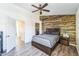 Bedroom showcasing a wood accent wall, ceiling fan, and neutral gray linens at 6262 E Brown Rd # 30, Mesa, AZ 85205
