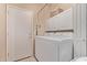 Well-lit laundry room featuring front load washer and dryer and overhead storage at 6350 S Wilson Dr, Chandler, AZ 85249