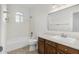 Clean bathroom featuring a tub/shower combo, modern sink and wooden cabinets at 654 W Natal Cir, Mesa, AZ 85210
