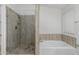 Bright bathroom featuring a glass enclosed shower and soaking tub with tile accents at 654 W Natal Cir, Mesa, AZ 85210