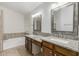 Bathroom with dual sinks, granite countertops, framed mirrors and a bathtub at 654 W Natal Cir, Mesa, AZ 85210