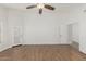 A spacious bedroom with wood floors, a ceiling fan, and white doors at 654 W Natal Cir, Mesa, AZ 85210