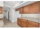 Bright kitchen featuring tile floors, granite countertops, backsplash, and wooden cabinets at 654 W Natal Cir, Mesa, AZ 85210