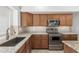 A kitchen featuring stainless steel appliances, granite countertops and wooden cabinets at 654 W Natal Cir, Mesa, AZ 85210