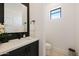 Chic powder room featuring modern vanity, sleek fixtures, and stylish black tile accents at 670 E Woburn Ln, Phoenix, AZ 85085