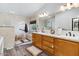 Bathroom featuring a double sink vanity, walk-in shower, soaking tub, neutral walls, and wood-look floors at 6960 W Peoria Ave # 29B, Peoria, AZ 85345