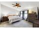Spacious main bedroom with carpet flooring, ceiling fan, double-hung windows with curtains, and comfortable king-sized bed at 6960 W Peoria Ave # 29B, Peoria, AZ 85345