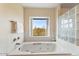 Bright bathroom showcasing a jacuzzi tub next to a window with natural light at 7220 E Mary Sharon Dr # 116, Scottsdale, AZ 85266