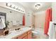 Bathroom featuring white tile, wood vanity, and shower with pink curtain at 7220 E Mary Sharon Dr # 116, Scottsdale, AZ 85266