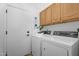 Laundry room featuring a door to the left, cabinets and a washer and dryer at 7544 E Sierra Morena Cir, Mesa, AZ 85207