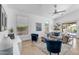 Bright living room featuring stylish blue chairs, a ceiling fan, and sliding glass doors at 7544 E Sierra Morena Cir, Mesa, AZ 85207