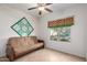 A cozy room featuring a futon, ceiling fan, and a window, providing a comfortable living space at 7726 E Baseline Rd # 134, Mesa, AZ 85209