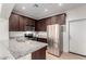 Modern kitchen with stainless steel appliances, granite countertops, and dark wood cabinets at 7726 E Baseline Rd # 134, Mesa, AZ 85209