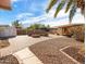 Spacious backyard featuring pavers, rocks, a fire pit area and covered outdoor kitchen with bar seating at 7726 W Cameron Dr, Peoria, AZ 85345
