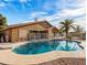 Backyard with a sparkling pool surrounded by a concrete patio and desert landscaping at 7726 W Cameron Dr, Peoria, AZ 85345