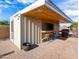 Outdoor kitchen with bar seating, corrugated metal siding and a grill on a paver patio at 7726 W Cameron Dr, Peoria, AZ 85345