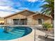 Back of house showing pool and patio area in a fenced backyard with a patio and desert landscaping at 7726 W Cameron Dr, Peoria, AZ 85345