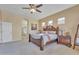 Bright main bedroom with a wooden bed frame, a ceiling fan, and bedside tables with lamps at 9626 W Bajada Rd, Peoria, AZ 85383