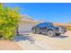 View of the home's side exterior with a well-maintained garage and adjacent driveway at 11816 S Winnebago St, Phoenix, AZ 85044