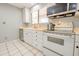 Well-lit kitchen with white appliances, tile flooring, and ample counter space for meal preparation at 11816 S Winnebago St, Phoenix, AZ 85044