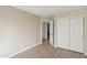 Neutral-toned bedroom features wood-look floors and closet with white sliding doors at 12075 N 110Th St, Scottsdale, AZ 85259