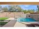 Beautiful backyard featuring a refreshing pool, well-manicured lawn, and stylish stone details at 12075 N 110Th St, Scottsdale, AZ 85259