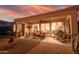 Inviting covered back patio featuring comfortable seating, an outdoor ceiling fan, and a view to the outdoor kitchen at 13068 W Mine Trl, Peoria, AZ 85383