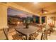 Covered back patio showcasing an outdoor dining set, ceiling fan, and landscaping, perfect for relaxing evenings at 13068 W Mine Trl, Peoria, AZ 85383