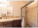 Bathroom showcasing tile shower with glass door and dark cabinets at 13068 W Mine Trl, Peoria, AZ 85383