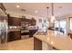 Well-equipped kitchen featuring a granite island, stainless steel appliances, and dark wood cabinets at 13068 W Mine Trl, Peoria, AZ 85383