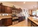 Kitchen with dark wood cabinetry, granite countertops, and stainless-steel appliances creating a sleek design at 13068 W Mine Trl, Peoria, AZ 85383