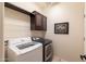 Functional laundry room with front load washer and dryer and overhead cabinet at 13068 W Mine Trl, Peoria, AZ 85383