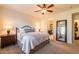 Spacious main bedroom featuring ceiling fan, king bed and ensuite bathroom access at 13068 W Mine Trl, Peoria, AZ 85383
