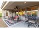 A covered patio with comfortable seating and an outdoor ceiling fan creating a relaxing ambiance at 13068 W Mine Trl, Peoria, AZ 85383