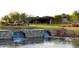 Scenic view of a stone water feature and golf course with a clubhouse in the background on a sunny day at 13068 W Mine Trl, Peoria, AZ 85383